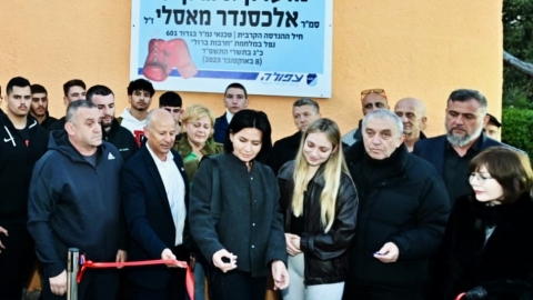 משפחת מאסליי גוזרים את הסרט של המועדון.jpg